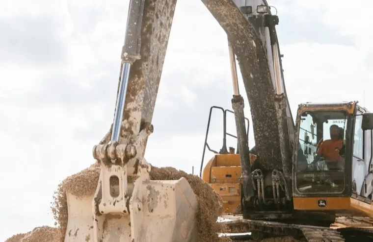 A tracked excavator scooping dirt at a construction site