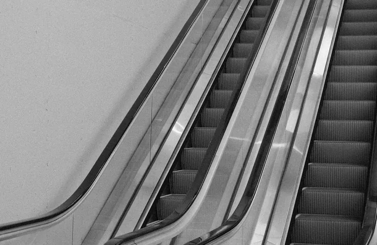 A pair of escalators ascending side by side inside a building
