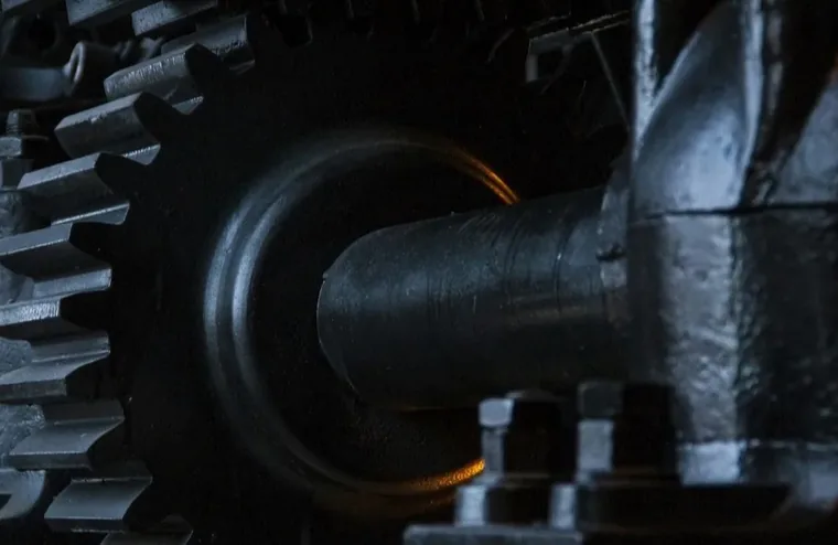 Close-up of a large gear and shaft on a piece of industrial machinery