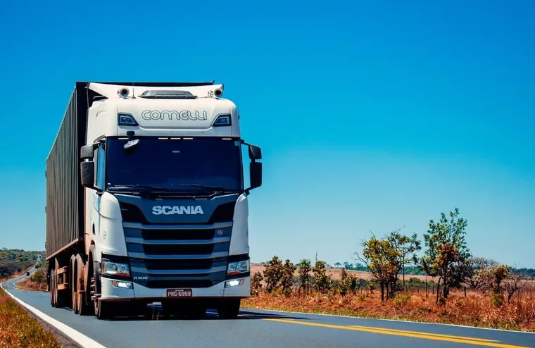 A heavy goods truck with a box trailer travelling along an open highway